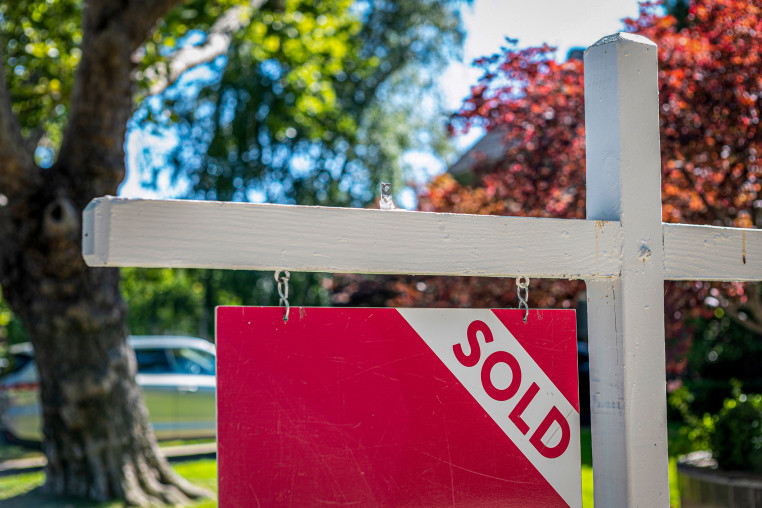 A "Sold" sign in front of a home.