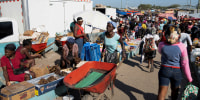 A woman pushes a wheelbarrow