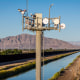 Cameras on a surveillance tower monitor, mountain landscape in the distance